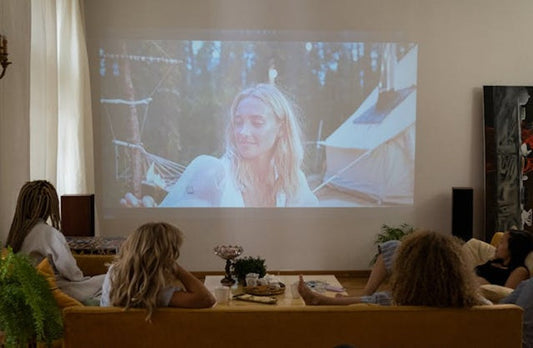 Friends watching a movie projected on a living room wall