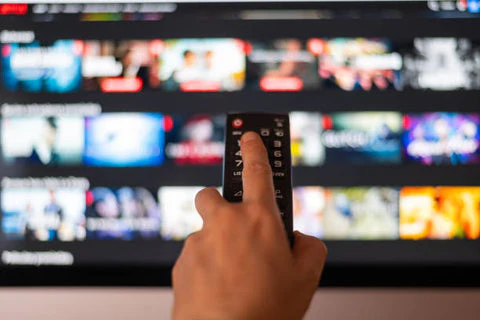 Hand using a projector remote to browse streaming content