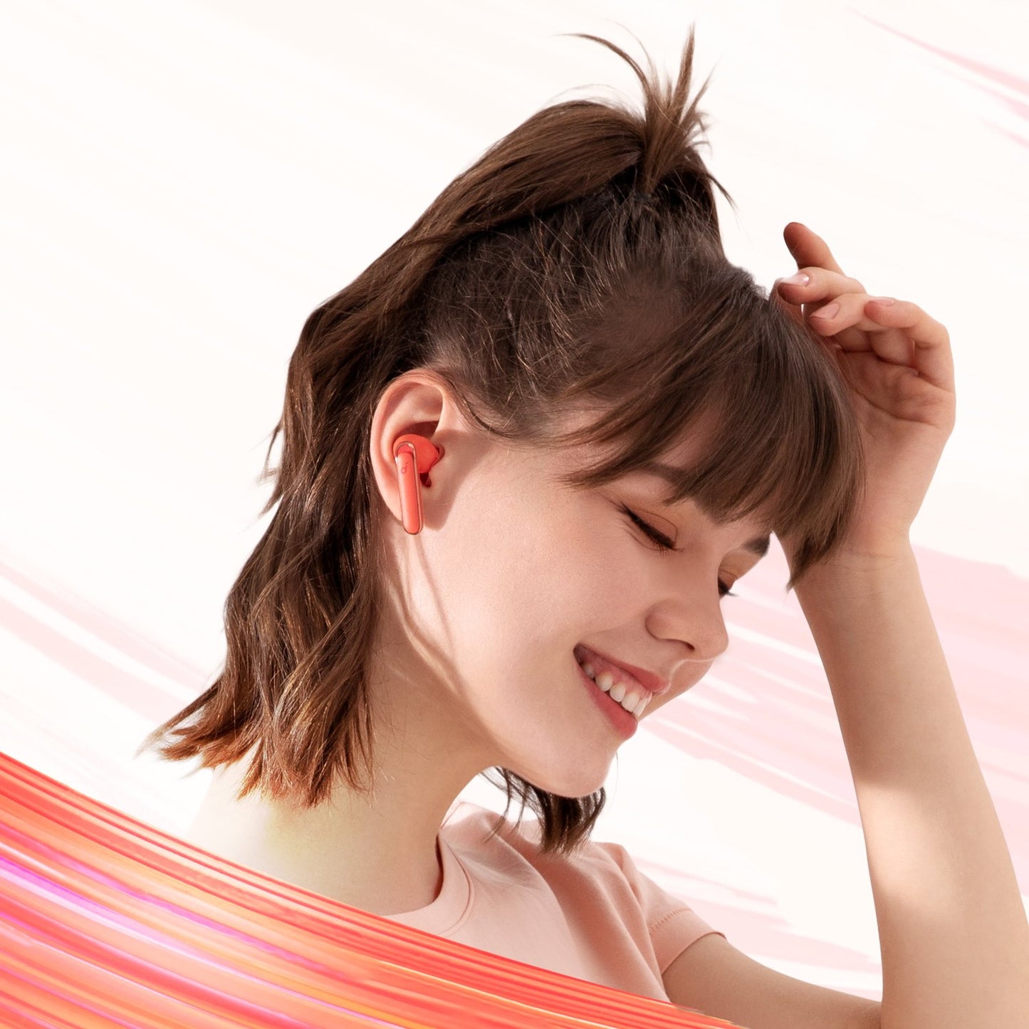 soundcore orange earbuds worn with stylish hair and hand gesture