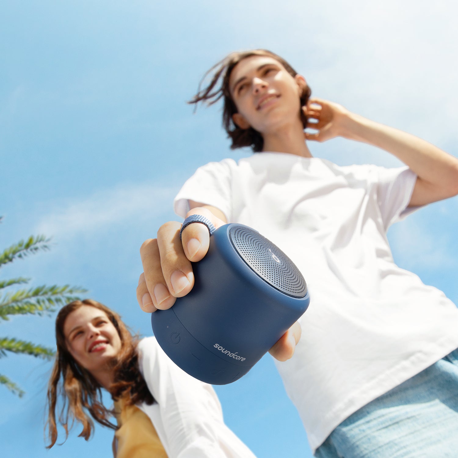 person holding soundcore portable speaker with outdoor background